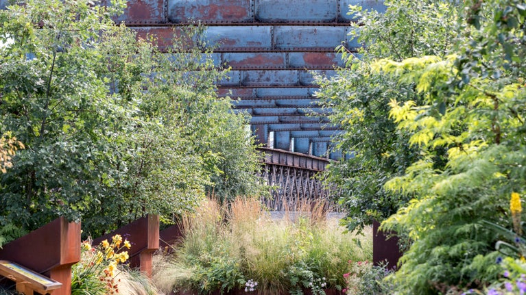 View of tree planting and steel structure at Castlefield Viaduct, Manchester